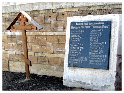 Крест и мемориальная плита в память погибших в аквапарке